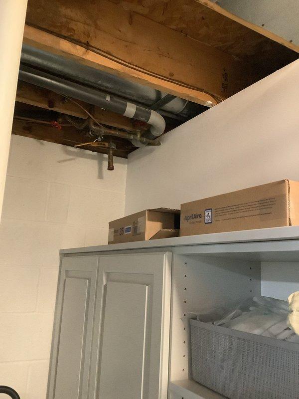 Responded to water leak complaint with visible ceiling damage above basement shower area. Upon investigation, identified condensation forming on exposed ductwork in unconditioned basement space, causing moisture to drip onto ceiling below and create water staining. Ductwork lacked proper insulation, allowing warm, humid air to contact cold supply duct surfaces during cooling operation, resulting in sweating condition. Documented existing water damage to ceiling with photographic evidence showing brown discoloration and moisture penetration. Explained condensation issue to homeowner and recommended insulating exposed ductwork with appropriate R-value duct wrap to prevent future sweating and moisture damage.