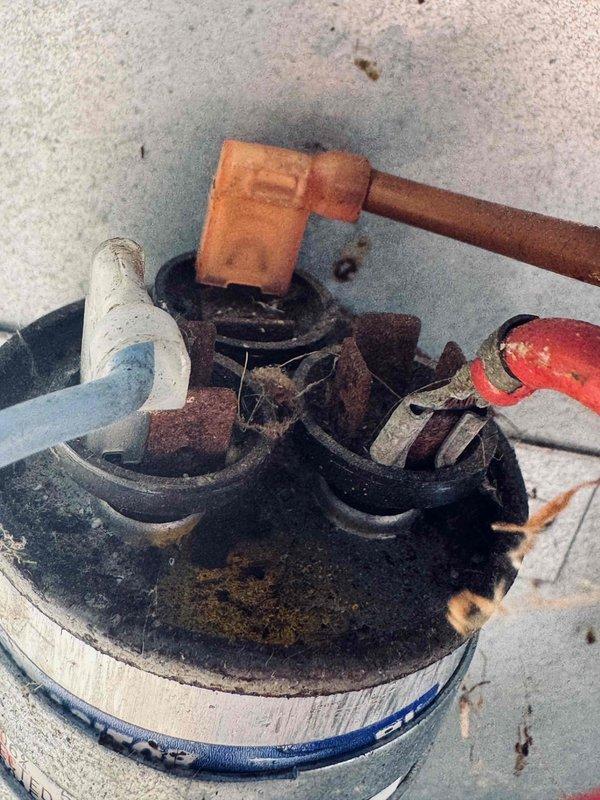 # HVAC Service Report - No Cool Condition

Responded to a no cooling complaint for a 19-year-old air conditioning system serving the second floor. Upon arrival and inspection, discovered the outdoor condensing unit in severely deteriorated condition with extensive corrosion on the refrigerant line connections and service valves. The suction line, liquid line, and service port assembly showed heavy rust and oxidation, indicating prolonged exposure to environmental elements and lack of maintenance over the system's lifespan.

Further inspection revealed critically compromised electrical wiring at the outdoor unit. The wire insulation had completely degraded and was crumbling, exposing bare conductors. Multiple layers of protective covering had failed, creating a serious electrical hazard and preventing proper unit operation. The deteriorated wiring showed evidence of long-term neglect with accumulation of debris and environmental contamination.

Given the age of the equipment and the ext