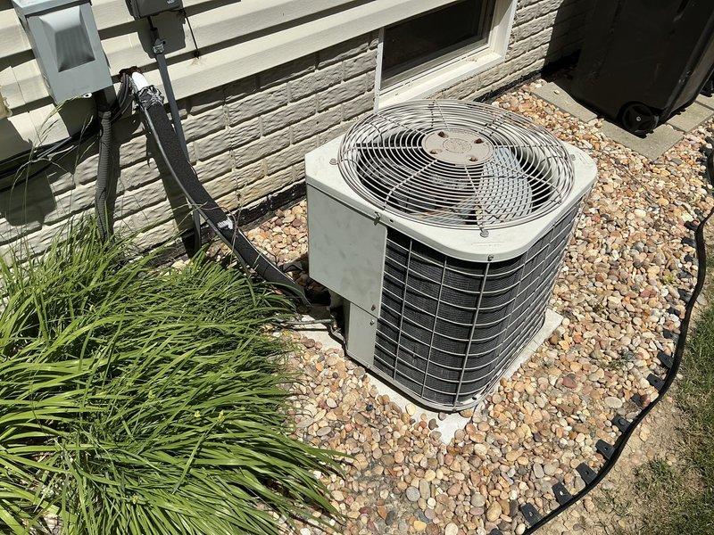 Completed comprehensive HVAC system replacement estimate for residential furnace and air conditioning equipment. Assessed existing installation including basement-mounted air handler with galvanized ductwork and exterior condensing unit positioned on gravel pad adjacent to building exterior. Documented current system configuration, ductwork condition with support strapping, refrigerant line routing, and electrical connections for equipment replacement specifications.