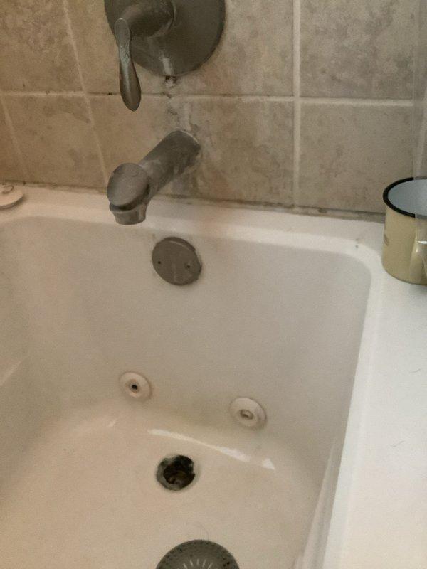 Responded to multiple plumbing concerns including a basement shower leak, reduced water pressure, and refrigerator water line leak. Inspected jetted bathtub fixtures and aging tub spout/shower diverter valve showing significant oxidation and wear. Examined basement plumbing infrastructure, including PVC P-trap drain assembly beneath floor joists serving upper level fixtures. Assessed drain system connections and mounting hardware for proper installation and potential leak sources. Documented condition of plumbing components and fixtures to address reported water leak issues and pressure concerns.