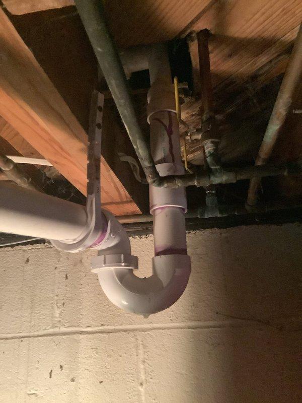 Responded to multiple plumbing concerns including a basement shower leak, reduced water pressure, and refrigerator water line leak. Inspected jetted bathtub fixtures and aging tub spout/shower diverter valve showing significant oxidation and wear. Examined basement plumbing infrastructure, including PVC P-trap drain assembly beneath floor joists serving upper level fixtures. Assessed drain system connections and mounting hardware for proper installation and potential leak sources. Documented condition of plumbing components and fixtures to address reported water leak issues and pressure concerns.
