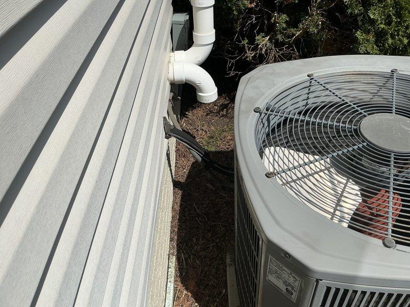 Conducted on-site assessment of 16-year-old residential air conditioning system for replacement estimate. Evaluated existing outdoor condenser unit condition, documented equipment specifications, and photographed current installation including unit placement, refrigerant line routing, and condensate drainage configuration to provide comprehensive replacement proposal.