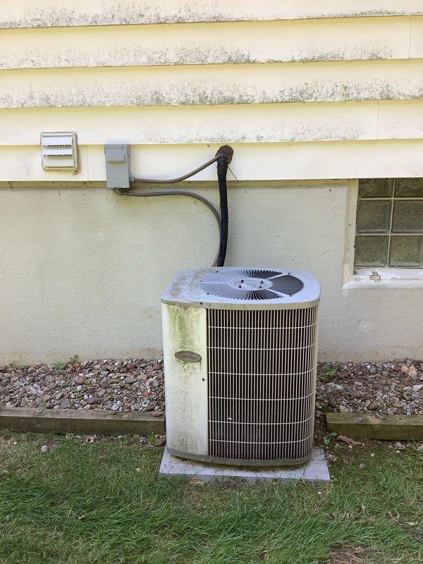 Completed installation of new air conditioning system including outdoor condenser unit and indoor evaporator coil. Outdoor condenser unit was positioned on existing concrete pad against building exterior with proper electrical disconnect and refrigerant line connections. Indoor evaporator coil was installed in conjunction with existing Carrier air handler unit in basement mechanical room. Refrigerant lines were run between outdoor and indoor components, properly insulated and secured along building exterior and through basement. System was evacuated, charged to manufacturer specifications, and tested for proper operation. All electrical connections were completed per code requirements, condensate drain lines were installed and verified for proper drainage, and system airflow was confirmed. Unit was started up successfully and left in operational condition.