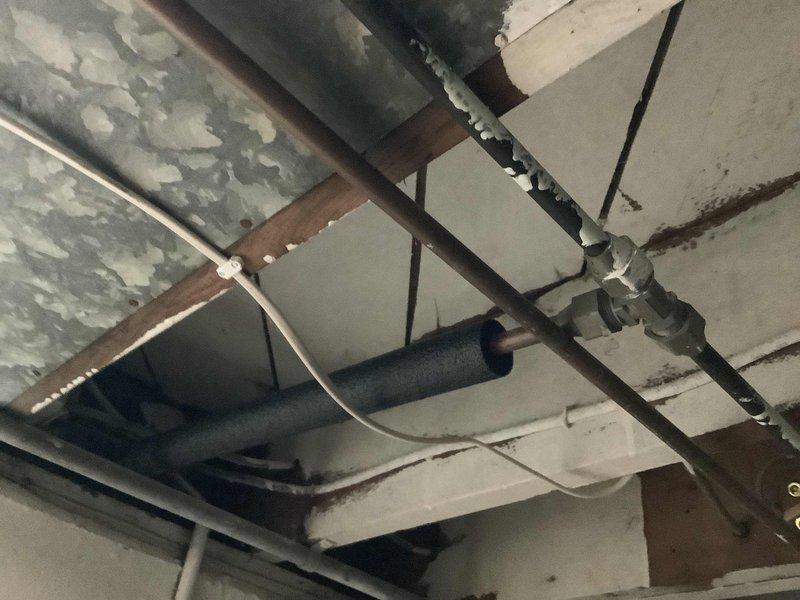 Responded to emergency call for burst cold water line supplying outdoor spigot. Upon arrival, found homeowner had shut off main water supply to stop active flooding. Accessed affected piping in basement/crawlspace area where copper supply line had failed. Assessed damage to water line and surrounding infrastructure, including proximity to HVAC ductwork and ceiling joists. Documented existing plumbing configuration showing multiple copper lines, insulated piping, and connection points. Evaluated extent of water damage to ceiling materials and structural components. Provided diagnostic assessment of failed pipe section and recommended repair options to restore water service to the property.