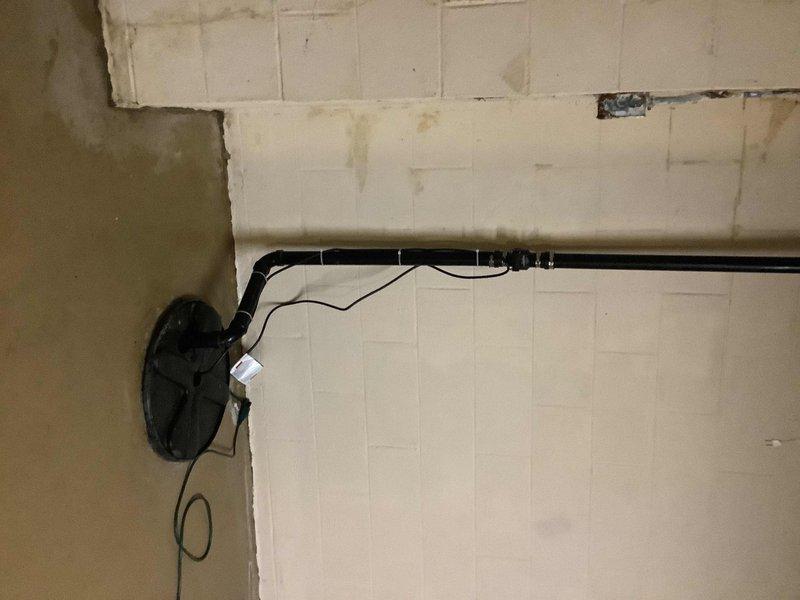 Responded to service call for non-operational sump pump system in residential basement. Upon arrival, found sump pump failed to activate, resulting in water intrusion and significant moisture damage to basement walls as evidenced by extensive staining and discoloration on painted concrete block surfaces. Inspected sump pit and pump assembly, identifying pump failure as primary cause of malfunction. Removed failed pump unit from pit and installed replacement sump pump with appropriate float switch mechanism. Verified proper electrical connections and tested pump operation through multiple cycles to ensure reliable activation at correct water levels. Confirmed discharge piping system remained intact and functional with no blockages or leaks present in horizontal run.