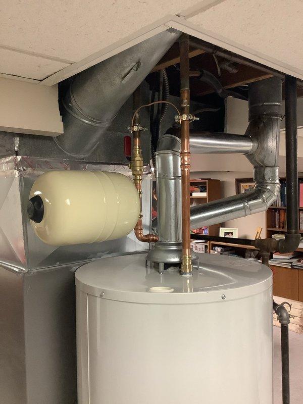 Removed existing water heater and installed new Bradford White 50-gallon residential water heater in utility area. Positioned unit in water safety pan with drain line routed to nearby floor drain for code compliance. Replaced existing shut-off valve with code-approved shut-off valve and installed new thermal expansion tank to protect against pressure buildup. Modified carpet flooring as necessary to accommodate proper installation of water pan. Connected all copper supply lines and verified proper operation of all plumbing connections. Registered new water heater unit with manufacturer upon completion, activating 6-year warranty coverage.