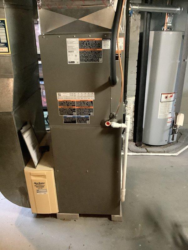 Completed installation of new air conditioning system and evaporator coil in residential basement mechanical room. Unit was properly positioned, connected to existing ductwork, and all condensate drainage lines were installed with PVC piping to ensure proper system operation and efficiency.