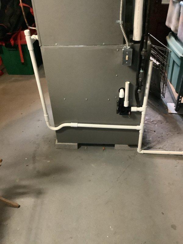 Completed installation of new air conditioning system and evaporator coil in residential basement mechanical room. Unit was properly positioned, connected to existing ductwork, and all condensate drainage lines were installed with PVC piping to ensure proper system operation and efficiency.