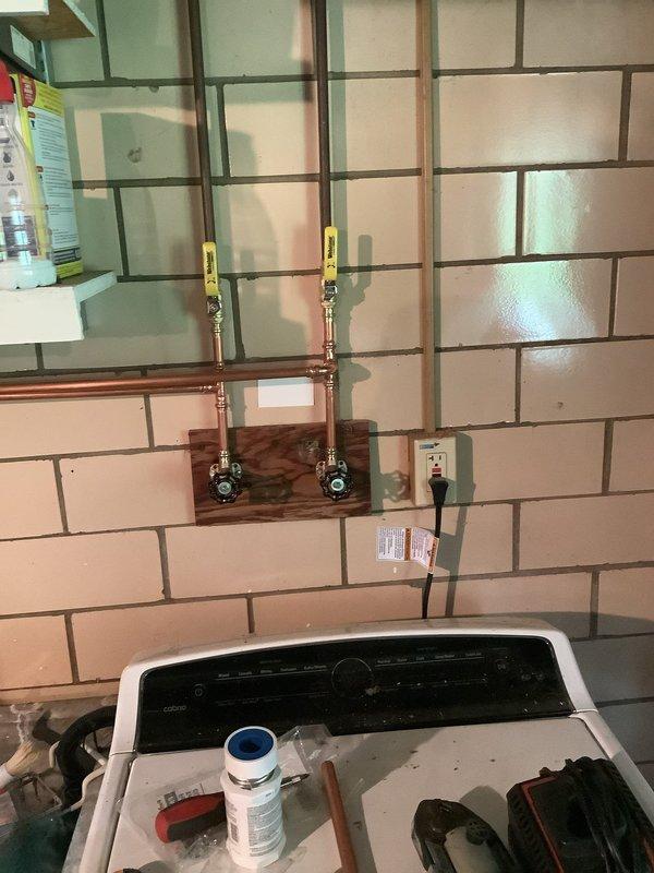Replaced hot and cold shut-off valves in garage, installed new laundry room faucet, and replaced boiler drains. Work included mounting new copper supply lines with ball valves on backing boards and connecting flexible supply hoses to appliances. Job involved Jack and Jill sink configuration with notation that drywall access in closet behind sinks may be required for drain cable routing if blockage extends between traps.