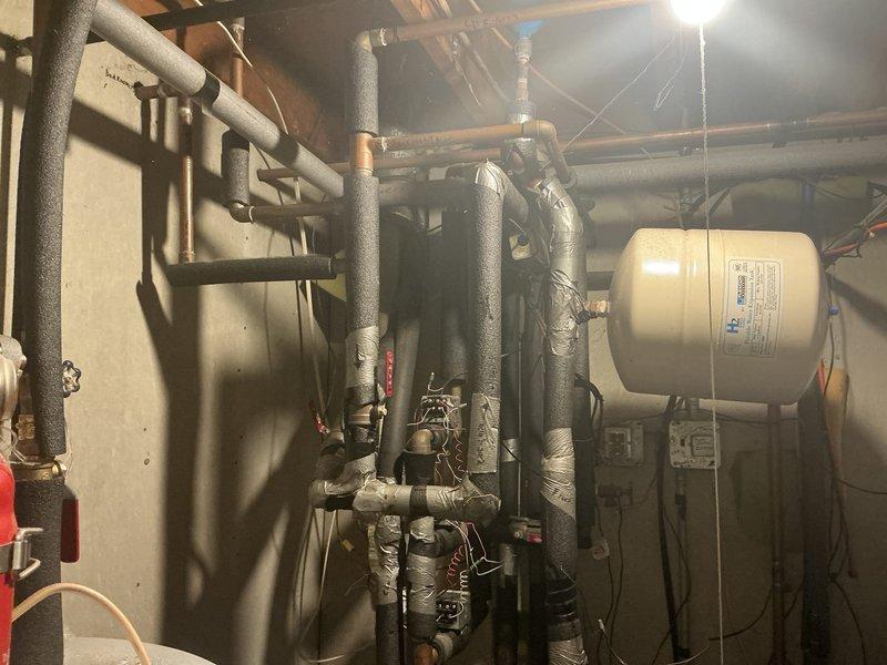 Conducted comprehensive assessment of existing hydronic heating system with open loop geothermal installation in residential property. Evaluated current mechanical room configuration including boiler system, insulated piping network, expansion tank, control valves, and associated electrical components to determine feasibility of complete system removal and replacement. Documented existing equipment conditions and electrical panel capacity to develop alternative HVAC solutions suitable for the property's infrastructure and heating/cooling requirements.