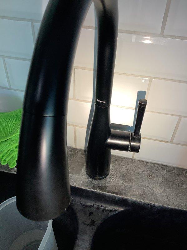 Responded to kitchen faucet leak complaint and performed comprehensive assessment of existing matte black faucet installation. Inspected above-counter components including tall curved spout, dual vertical supply pipes, and side spray attachment for signs of wear or damage. Examined under-sink plumbing connections, including chrome angle stop valves, flexible braided supply lines, and drain assembly. Discussed repair versus replacement options with customer, documented current installation with photographs, and provided recommendations for addressing the leak issue based on fixture condition and customer preferences.