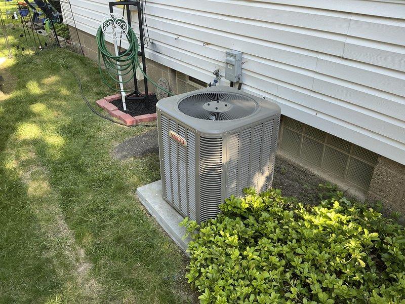 Completed on-site assessment of 10-year-old Lennox air conditioning system experiencing refrigerant leak. Inspected outdoor condensing unit positioned on concrete pad alongside residence and evaluated indoor evaporator coil assembly with associated PVC condensate drain lines and copper refrigerant piping. Documented equipment condition through photographs and provided replacement estimate for complete HVAC system due to age of existing equipment and cost-effectiveness of replacement versus repair.