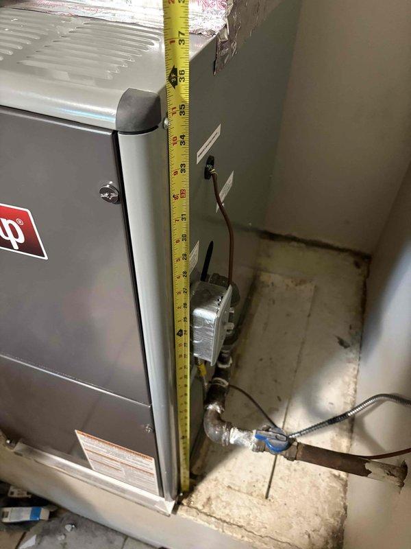 Conducted on-site estimate for central air conditioning installation at 1,152 square foot single family residence with recently installed furnace and coil (approximately 4-5 months old). Assessed existing HVAC infrastructure including furnace clearances, ductwork configuration, refrigerant line routing, electrical panel capacity with available 100-amp main service and identified furnace circuit, and condensate drainage system with blue valve assembly. Documented mechanical room layout, overhead duct connections, and copper line placement to determine equipment compatibility and installation requirements for new AC system.