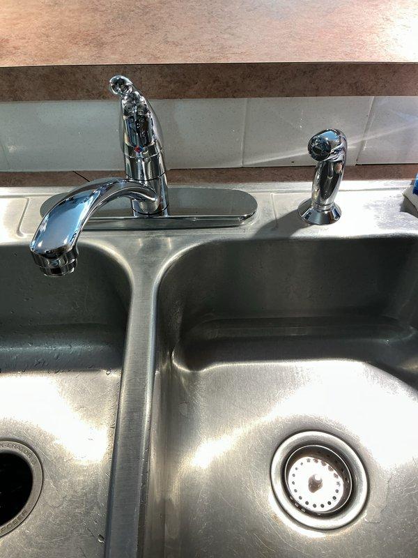 Completed comprehensive plumbing fixture replacement throughout the residence. Installed new chrome dual-handle lavatory faucet in first floor bathroom with proper water supply connections and drain assembly. Replaced kitchen faucet with stainless steel single-handle unit including integrated spray attachment, mounted on double-basin stainless steel sink with updated deck plate configuration. Installed two matching chrome dual-handle lavatory faucets in master bathroom, ensuring proper hot and cold water supply connections and drain linkages. Replaced existing sump pump system in basement with new unit and installed fresh check valve to prevent backflow and ensure proper discharge operation. Removed and replaced exterior garage sillcock with frost-proof model, verifying proper pitch for drainage and secure mounting to exterior wall. All fixtures tested for proper operation, water pressure, and leak-free connections upon completion.