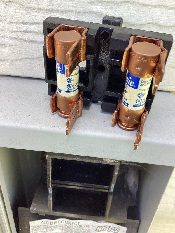 Completed MVP cooling maintenance visit on 12-year-old air conditioning system. Inspected electrical disconnect box, confirming Bussmann fuses properly seated in dual-position holder with secure copper spring clip contacts. Examined interior cabinet components including dual-run capacitor, contactor relay, and EMC-labeled component. Verified all electrical connections with color-coded wiring intact and properly terminated with wire nuts where appropriate. Unit operational following standard preventive maintenance protocol.