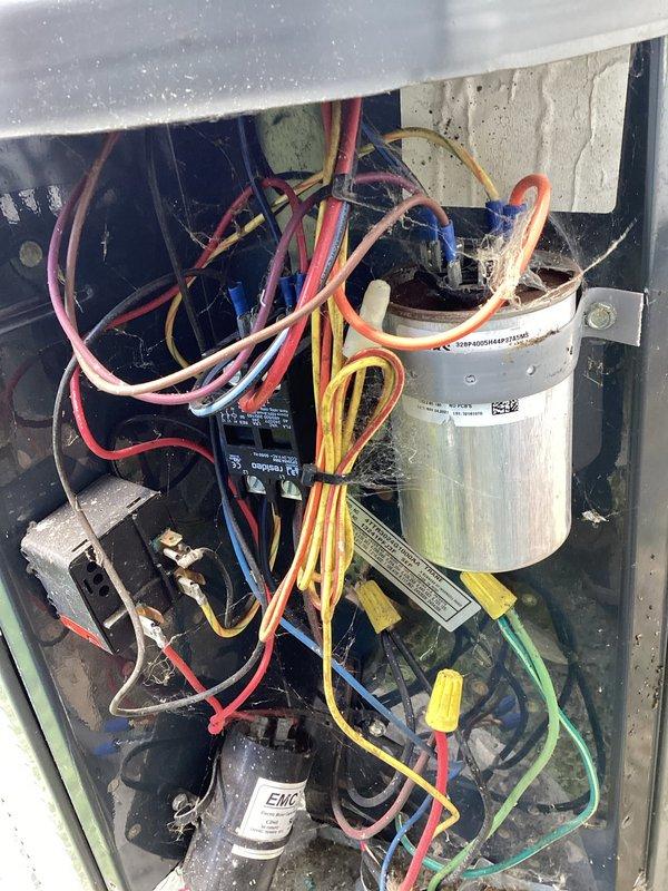 Completed MVP cooling maintenance visit on 12-year-old air conditioning system. Inspected electrical disconnect box, confirming Bussmann fuses properly seated in dual-position holder with secure copper spring clip contacts. Examined interior cabinet components including dual-run capacitor, contactor relay, and EMC-labeled component. Verified all electrical connections with color-coded wiring intact and properly terminated with wire nuts where appropriate. Unit operational following standard preventive maintenance protocol.