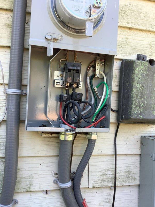 Responded to service call for exterior main breaker repeatedly tripping, with customer reporting issue worsening during hot weather and breaker running hot to touch after shutting off all 220V appliances. Upon arrival, inspected exterior electrical service panel and photovoltaic system AC disconnect mounted on building exterior. Found main breaker exhibiting signs of thermal stress and heat-related failure. Conducted thermal assessment of breaker and connections, identifying excessive heat buildup in main breaker assembly during high ambient temperature conditions. Documented existing electrical service configuration including meter base, main disconnect, and solar system integration points. Photographed weathered exterior panel installation showing EATON service equipment and associated solar disconnect enclosure with conduit connections. Issue determined to be heat-related breaker degradation causing nuisance tripping under load during elevated outdoor temperatures. Recommended break