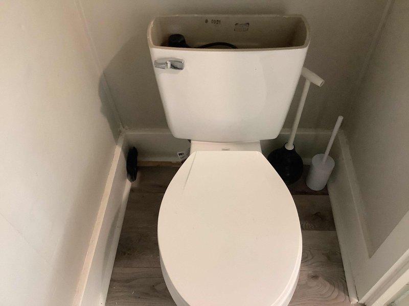 Responded to service call for leaking toilet tank in historic residential property with updated plumbing systems. Upon inspection, identified water dripping from tank assembly on standard two-piece white porcelain toilet fixture. Diagnosed faulty tank-to-bowl connection gasket and deteriorated tank bolts causing visible water seepage. Shut off water supply at fixture stop valve and drained tank completely. Removed existing hardware and replaced worn rubber gasket, tank bolts, and washers with new components. Ensured proper alignment of tank to bowl during reassembly and torqued mounting bolts to manufacturer specifications to prevent over-tightening and potential porcelain damage. Restored water supply and conducted multiple flush cycles to verify leak elimination and proper tank refill operation. Inspected surrounding areas for water damage and confirmed no additional issues with bowl seal or supply line connections. Fixture restored to full working condition with no further leakage d