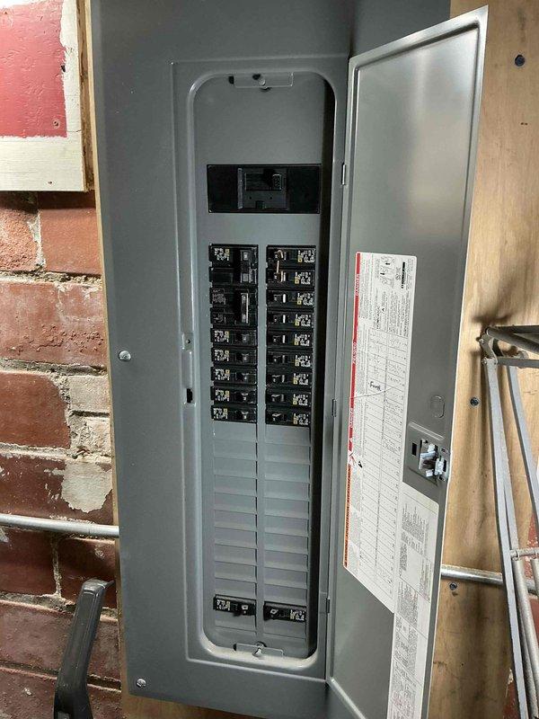Completed installation of a 1-to-1 mini split system on brick exterior structure. Installed outdoor condenser unit using extension ladder for elevated mounting, ran refrigerant lines and electrical connections to interior air handler, and integrated electrical disconnect into existing breaker panel with proper circuit protection.