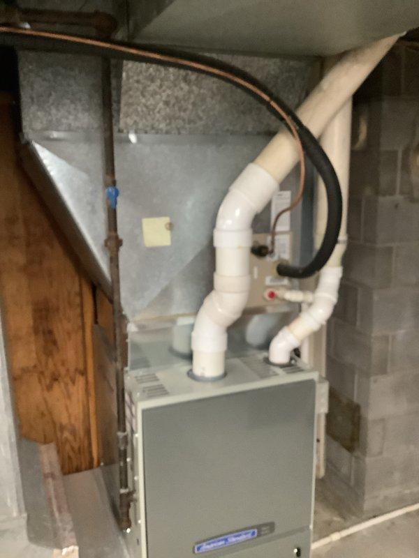 Completed first-time air conditioning installation with new evaporator coil in residential basement location. Installed indoor evaporator coil unit, connected copper refrigerant lines to existing furnace system, and integrated white insulated supply ductwork for proper air distribution. Routed refrigerant lines along ceiling joists, secured all connections, and verified proper integration with heating system for year-round climate control operation.
