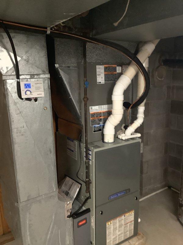 Completed first-time air conditioning installation with new evaporator coil in residential basement location. Installed indoor evaporator coil unit, connected copper refrigerant lines to existing furnace system, and integrated white insulated supply ductwork for proper air distribution. Routed refrigerant lines along ceiling joists, secured all connections, and verified proper integration with heating system for year-round climate control operation.