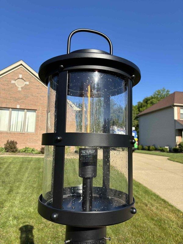Replaced damaged lamp socket on outdoor post light fixture. Previous installation revealed defective socket component, which customer procured for replacement. Removed existing damaged socket assembly from cylindrical lantern-style fixture, installed new socket, verified proper electrical connections, and tested light operation. Fixture now fully functional with LED element operating correctly.
