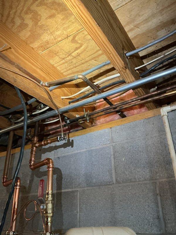 Responded to service call for leaking garbage disposal unit beneath kitchen sink. Upon inspection, identified leak originating from InSinkErator disposal unit's mounting assembly and drain connections. Tightened mounting flange and securing mechanisms at sink drain opening, then inspected and resealed discharge tube connections where black rubber hoses attach to disposal housing. Verified all plumbing connections were secure and tested unit operation to confirm leak was resolved. Unit returned to proper working condition with no further water discharge detected.