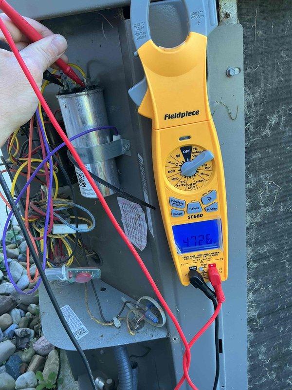 Completed comprehensive MVP cooling maintenance visit on 10-year-old air conditioning system. Performed visual inspection of outdoor condenser unit, noting heavy accumulation of dirt, dust, and debris on exterior coil fins requiring attention. Conducted electrical diagnostics using clamp meter to verify system performance, measuring capacitance and amperage readings within the control panel to ensure proper component operation and electrical integrity of the unit.