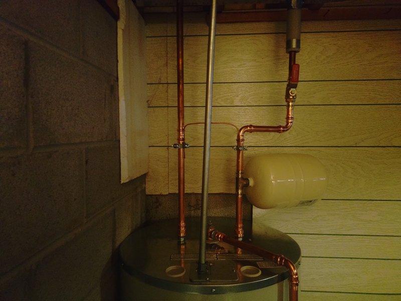 Replaced 50-gallon residential water heater in basement utility area. Installed new unit with complete water heater kit, configured copper supply and discharge piping with proper connections and fittings, and insulated hot water lines to prevent heat loss. All plumbing connections tested and verified operational upon completion.