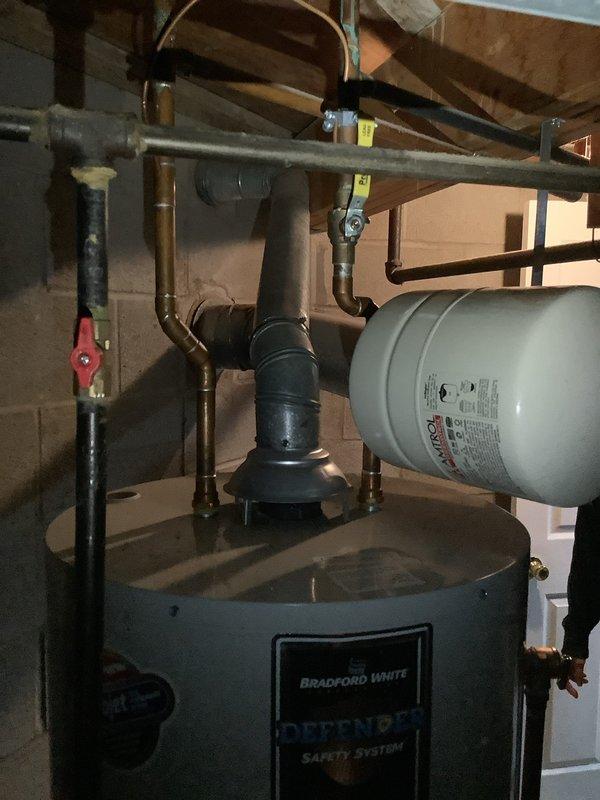 Responded to service call for water heater evaluation under warranty. Upon inspection, found Bradford White Defender series water heater with proper expansion tank and safety system components installed. Examined unit's control panel, temperature settings, and internal wiring connections. Assessed all copper piping connections, shut-off valves, and thermal insulation for proper installation and operation. Documented current condition of water heater system with detailed photographs showing exterior installation, plumbing connections, expansion tank mounting, and internal control components. Unit appears to be functioning within normal parameters with appropriate safety features in place. Provided homeowner with assessment findings and warranty service recommendations for any necessary repairs or replacement through manufacturer.