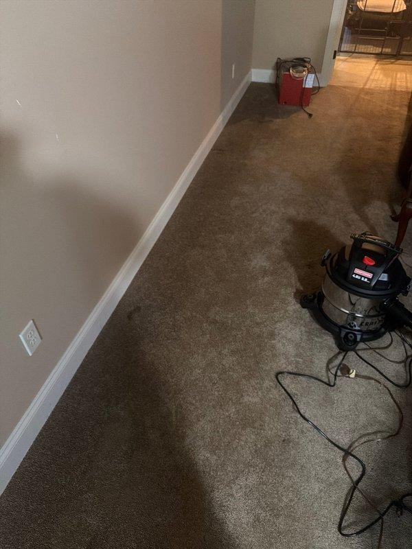 Responded to service call for leaking exterior hose bibb at residential property. Upon arrival, discovered failed frost-free sillcock had allowed water to penetrate interior wall cavity, causing significant water damage to carpeted hallway. Shut off water supply to affected fixture and extracted standing water from carpet using wet/dry vacuum. Removed defective exterior faucet assembly and inspected wall penetration for extent of moisture intrusion. Installed replacement frost-free sillcock with proper pitch for drainage and verified secure mounting to exterior wall sheathing. Applied weatherproof silicone sealant around exterior trim plate to prevent future water entry. Tested new faucet assembly under full pressure to confirm proper operation and absence of leaks. Recommended homeowner monitor interior carpet for additional moisture and consider professional carpet cleaning or replacement if staining persists.