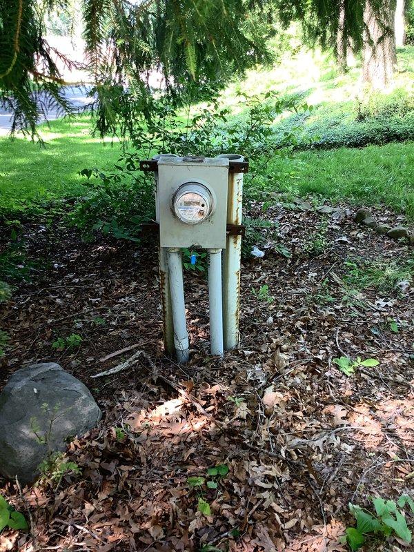 Responded to service call for electrical system inspection at residential property. Upon arrival, performed comprehensive evaluation of outdoor meter installation and main service panel. Inspected weathered exterior meter enclosure mounted on pole assembly, verified meter functionality and secure mounting. Opened and examined interior service panel containing main disconnect switch and dual-column Square D breaker configuration. Verified all circuit breakers properly seated, checked torque on bus bar connections, and confirmed service disconnect labeling present and legible. Inspected incoming service conductors and panel wiring for proper termination and code compliance. All electrical connections found secure with no immediate safety concerns identified. Documented existing conditions with photographs for service records.