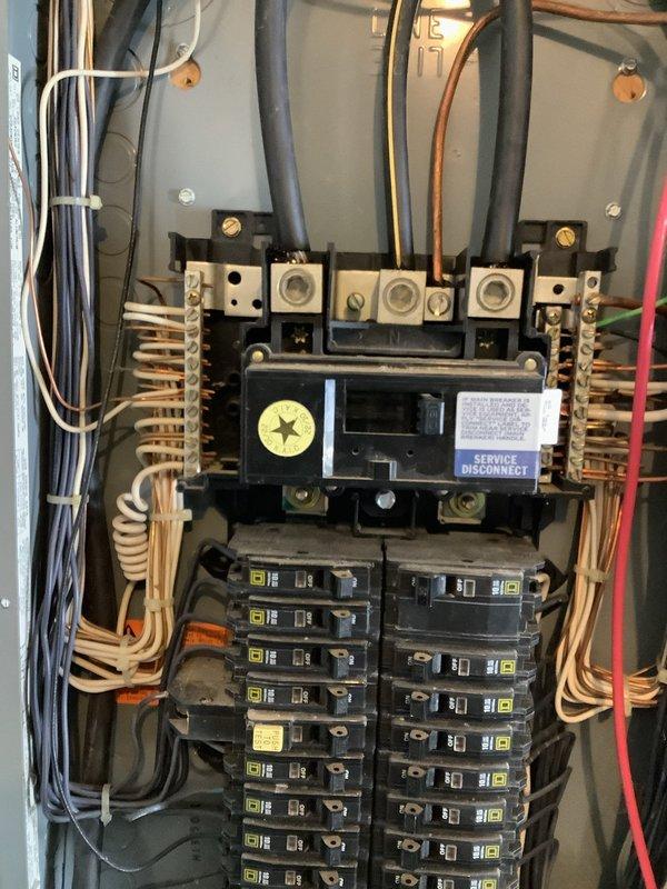 Responded to service call for electrical system inspection at residential property. Upon arrival, performed comprehensive evaluation of outdoor meter installation and main service panel. Inspected weathered exterior meter enclosure mounted on pole assembly, verified meter functionality and secure mounting. Opened and examined interior service panel containing main disconnect switch and dual-column Square D breaker configuration. Verified all circuit breakers properly seated, checked torque on bus bar connections, and confirmed service disconnect labeling present and legible. Inspected incoming service conductors and panel wiring for proper termination and code compliance. All electrical connections found secure with no immediate safety concerns identified. Documented existing conditions with photographs for service records.
