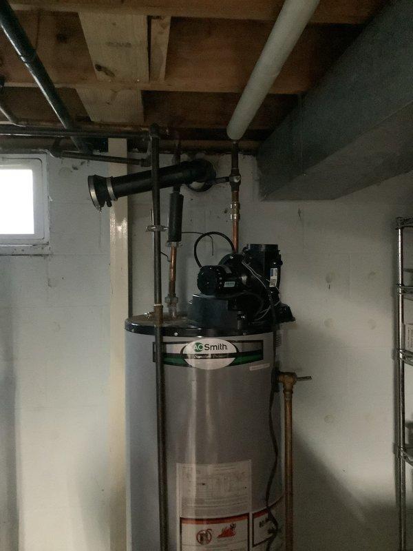 Conducted on-site assessment of existing A.O. Smith power vent tanked water heater located in basement utility area. Evaluated current unit's condition, including examination of the black power vent blower assembly mounted on top of the tank, connected copper and PVC piping configurations, and overall system integrity. Documented the installation with photographs showing the stainless steel tank, venting components, and plumbing connections to facilitate accurate replacement specifications. Prepared comprehensive estimate for new power vent water heater replacement, accounting for proper venting requirements and existing plumbing infrastructure compatibility.
