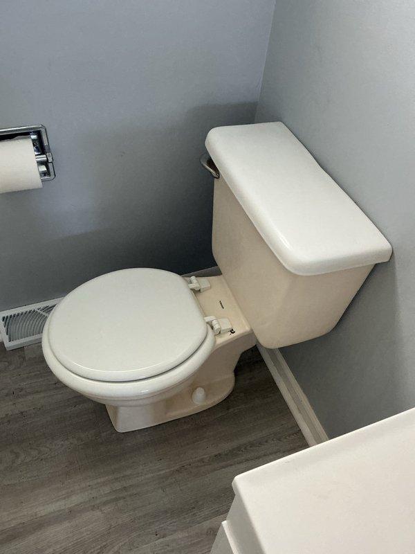 Completed comprehensive plumbing repairs including installation of new waste and overflow assembly in bathtub with new trap, adapting connection to existing 1 1/2" copper drain line. Removed first floor toilet, cut 3" copper drain line below floor level, and rebuilt with new PVC toilet flange, resetting toilet on new flange to ensure proper seal and stability. Installed new sump pump in basement, removing old flex discharge line and replacing with 1 1/2" PVC piping system with new check valve on discharge line to prevent backflow.