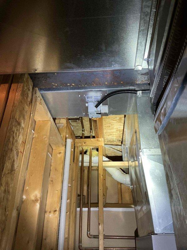 Conducted on-site evaluation of existing 13-year-old air conditioning system to provide replacement estimate. Assessed current HVAC equipment configuration including furnace, ductwork, and condensing unit accessibility. Documented existing installation setup in basement mechanical room, photographed Challenge brand air handler unit with connected ductwork, Lennox furnace cabinet, PVC condensate drainage lines, and exposed framing to determine proper sizing and installation requirements for new AC system replacement.