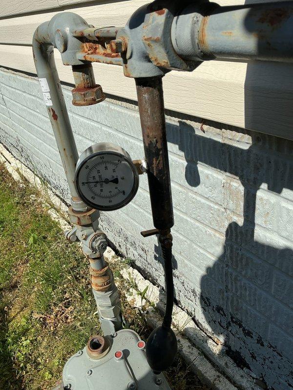 Responded to gas leak emergency at residential property. Upon arrival, identified 4-5 active natural gas leaks throughout the system. Immediately shut off gas supply to the home to ensure safety. Performed comprehensive pressure testing on the gas line system to locate all leak points. Inspection revealed leaks at multiple connection points and fittings, including exterior meter assembly with visible corrosion on blue-painted piping and brass components, as well as interior gas piping in crawlspace area. Documented all leak locations with photographs showing corroded pressure gauge assembly, weathered valve connections, and compromised pipe joints. Gas service remains isolated pending repair of all identified leaks before system can be safely restored to operation.