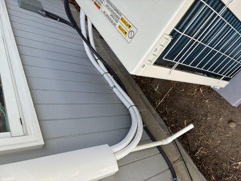 Installed dedicated electrical circuit for mini split air conditioning system. Ran gray flexible conduit from main electrical panel to exterior disconnect box mounted on building siding, then continued to outdoor condenser unit. Routed all electrical wiring in compliance with NEC standards, securing conduit along exterior wall with appropriate fasteners. Installed weatherproof disconnect switch on exterior wall for safe servicing access. Verified proper voltage, amperage, and grounding at unit upon completion. System tested and operational.