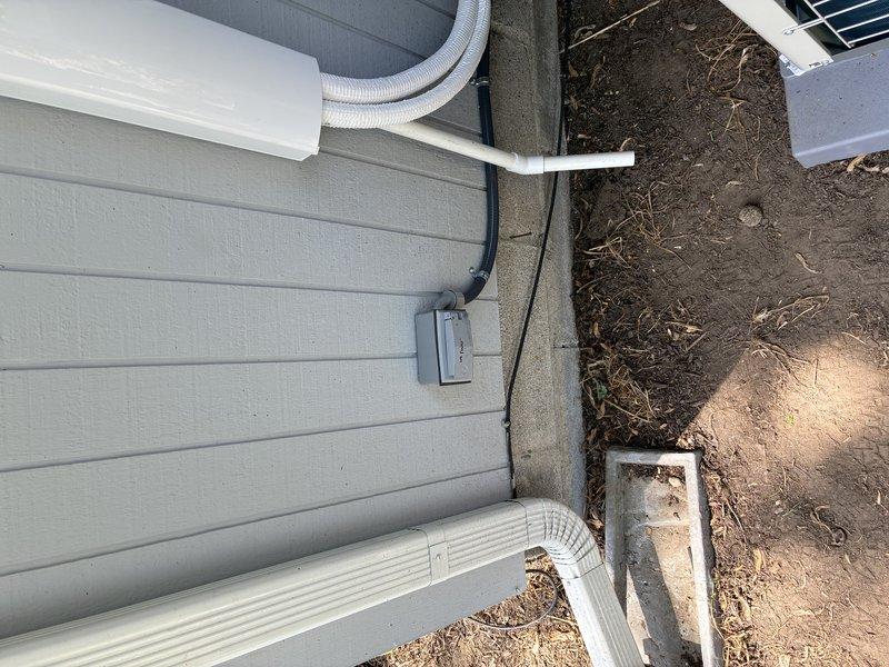 Installed dedicated electrical circuit for mini split air conditioning system. Ran gray flexible conduit from main electrical panel to exterior disconnect box mounted on building siding, then continued to outdoor condenser unit. Routed all electrical wiring in compliance with NEC standards, securing conduit along exterior wall with appropriate fasteners. Installed weatherproof disconnect switch on exterior wall for safe servicing access. Verified proper voltage, amperage, and grounding at unit upon completion. System tested and operational.