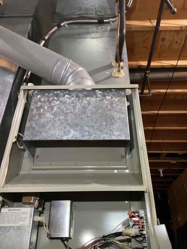 Responded to no-cooling complaint on 30+ year old air conditioning system. Found outdoor unit operating but indoor unit failing to deliver conditioned air. Upon inspection, discovered evaporator coil completely frozen with heavy ice buildup, preventing proper airflow and heat exchange. Internal ductwork showed rust staining and corrosion, indicating long-term moisture issues. System age and condition of components suggest restricted airflow or low refrigerant charge as likely causes of freeze-up. Documented coil condition and cabinet interior with photos for customer records.