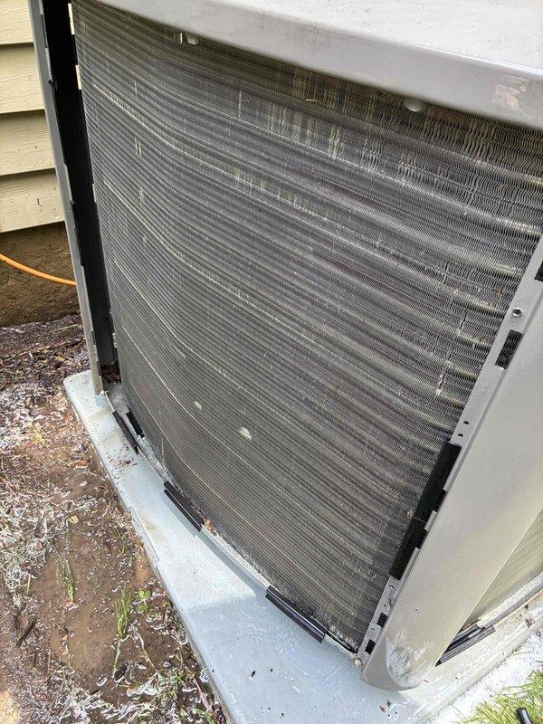 Completed MVP recurring cooling maintenance visit on residential Lennox outdoor condensing unit. Performed visual inspection of equipment exterior, verified proper placement on condensate pad, and inspected refrigerant line connections. Accessed internal components to examine condenser coil condition, noting dust and dirt accumulation on heat exchanger fins requiring attention during routine maintenance procedures.