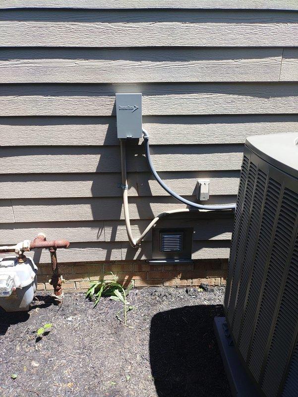 Completed full HVAC system installation including outdoor heat pump condenser unit and indoor air handler. Mounted heat pump on gravel pad adjacent to building exterior with proper clearances maintained. Installed dedicated electrical disconnect box with appropriate conduit and wiring run to unit per code requirements. Ran refrigerant line set through exterior wall penetration with copper piping properly secured and insulated. Connected all electrical components including power supply and control wiring between outdoor and indoor units. Installed flexible ductwork connections at air handler with proper sealing and insulation. Verified system startup with all electrical connections energized and operational. Performed temperature and performance measurements using calibrated digital instrumentation to confirm proper system operation and refrigerant charge levels. All installation work completed to manufacturer specifications and local building codes.