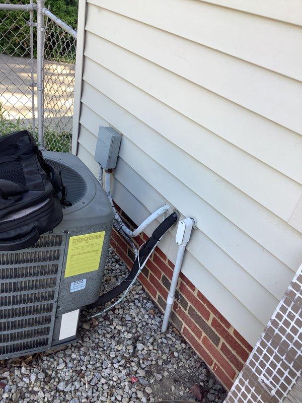 Performed comprehensive evaluation of existing HVAC system for replacement estimate. Assessed 40-year-old furnace and non-operational air conditioning condenser unit. Documented existing Goodman brand outdoor condenser installation, electrical disconnect, and drainage system configuration. Evaluated equipment placement, gravel pad condition, and electrical service connections to provide accurate replacement recommendations for complete heating and cooling system upgrade.