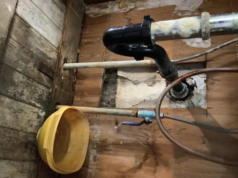 Responded to kitchen sink leak with suspected mold growth beneath fixture. Upon inspection, identified failed drain connection at P-trap assembly causing water intrusion into subfloor area. Accessed crawlspace to assess extent of moisture damage, confirming significant water staining on wooden subflooring and visible mold growth on adjacent wall surfaces. Replaced deteriorated drain components including P-trap and tailpiece connections, verified proper drainage flow, and recommended professional mold remediation for affected areas.