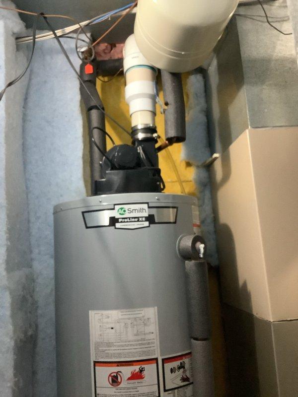 Completed water heater replacement in residential utility room. Removed existing unit and installed new A.O. Smith ProLine tanked water heater with proper plumbing connections, expansion tank, drain pan, and temperature control assembly. All copper and PVC piping configured to code specifications with system tested and operational upon completion.