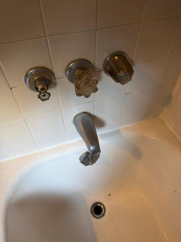 Responded to service call for leaky bathtub with worn fixtures. Inspected existing Price Pfister three-handle tub and shower valve assembly showing significant age-related deterioration, mineral buildup, and corrosion on trim components. Replaced all three corroded handle assemblies and trim pieces to restore proper operation and eliminate leak at fixtures. Verified water supply shutoffs functioning properly at copper supply lines. Tested repaired system for proper hot and cold water control and confirmed no active leaks at valve stems or spout connection upon completion.