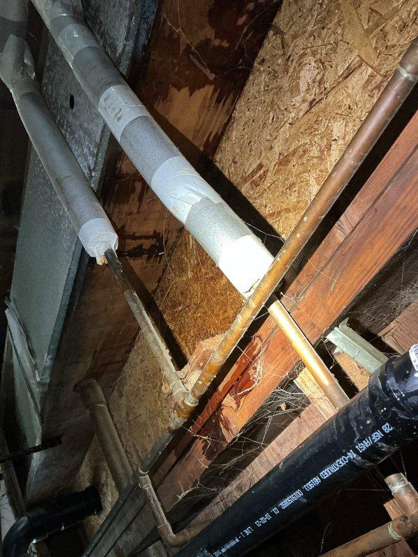 Responded to service call regarding suspected sewer gas odor affecting indoor air quality, with customer reporting respiratory irritation, eye and skin discomfort, and oily residue on walls. Conducted comprehensive inspection of plumbing system including bathroom stack, basement piping, and drain assemblies after fire department and gas company ruled out carbon monoxide and natural gas leaks. Documented existing conditions with photographs showing attic/crawl space plumbing infrastructure with PVC vent stack penetrations through structural framing, and under-sink drain assembly with visible water staining and discoloration on basin underside. Inspection revealed potential drain trap seal failure or compromised vent stack connections that could allow sewer gases to enter living space. Recommended further diagnostic testing of vent stack integrity and potential professional air quality assessment to identify source of reported symptoms and oily deposits.