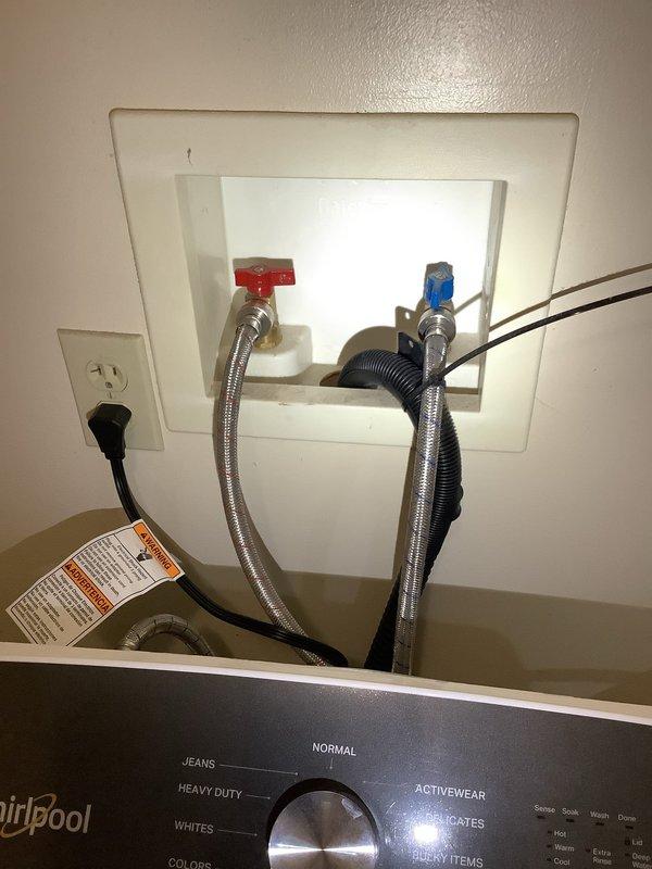 Responded to service call for non-functioning hot water supply to washing machine. Upon inspection, found the hot water shut-off valve (red handle) in the wall-mounted connection box was faulty and preventing water flow to the appliance. Replaced defective hot water valve, verified proper connection to braided stainless steel supply line, tested system operation, and confirmed hot water now flowing correctly to washing machine while cold water line remained functional throughout service.