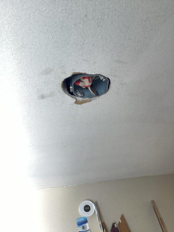 Responded to failed electrical inspection with multiple NEC 2023 code violations requiring correction. Replaced non-fan-rated light boxes in center of habitable rooms per 314.27(c). Installed required nail plates in multiple areas where cable protection was missing per 300.4A1. Added receptacle to 8' living room wall to meet proper wall spacing requirements per 210.52. Re-secured cable stapling throughout multiple areas to comply with 334.30 standards. Located and corrected open splice with equipment ground in wall cavity. Performed complete bathroom electrical rewire for two bathrooms to achieve full 2023 NEC code compliance, as original rough-in was incomplete. Verified all subpanel connections for proper termination and torque specifications. Documented all corrections with photographic evidence showing exposed wall sections, electrical boxes, and ceiling penetrations with visible wiring. Installation held pending re-inspection and manager approval for code compliance verification.