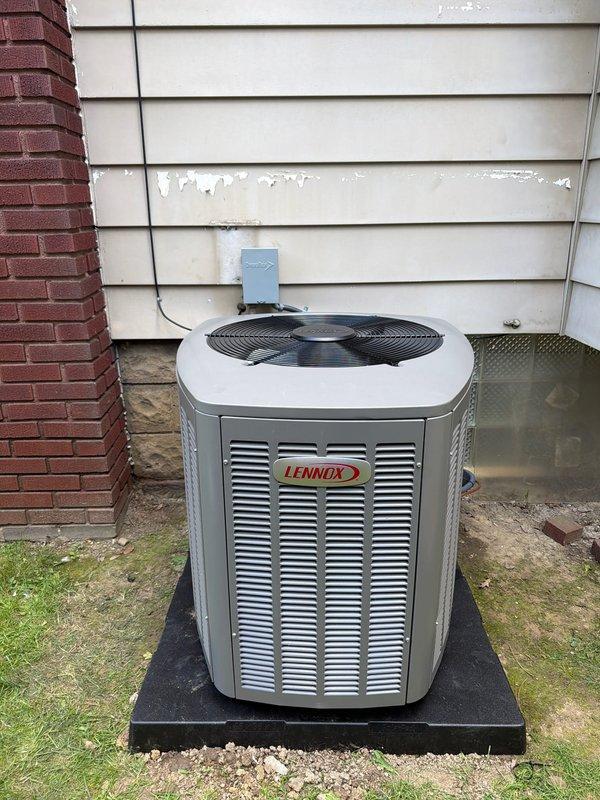 Completed full HVAC system installation including a 90% efficiency Trane furnace in the basement mechanical room and a Lennox air conditioning condenser unit on the exterior of the residence. The furnace was installed with proper PVC venting, connected to new ductwork and air handler components, with all equipment properly labeled and tagged per code requirements. The outdoor AC condenser was mounted on a composite pad against the home's exterior, with electrical conduit and refrigerant line set professionally routed to the wall-mounted disconnect box, completing a fully functional heating and cooling system.